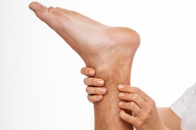 Physiotherapist palpating Achilles tendon